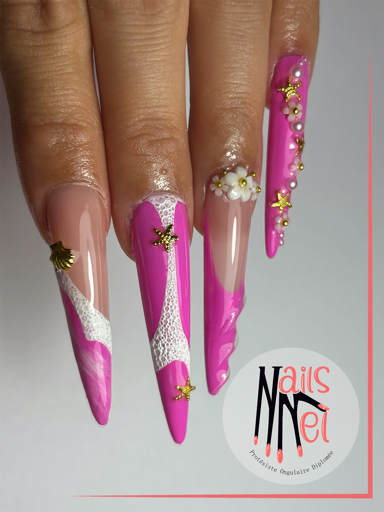 pose américaine réalisée à Hénin-Beaumont par Mélanie, prothésiste ongulaire, rose  avec accéssoires doré coquillages fleurs et perles